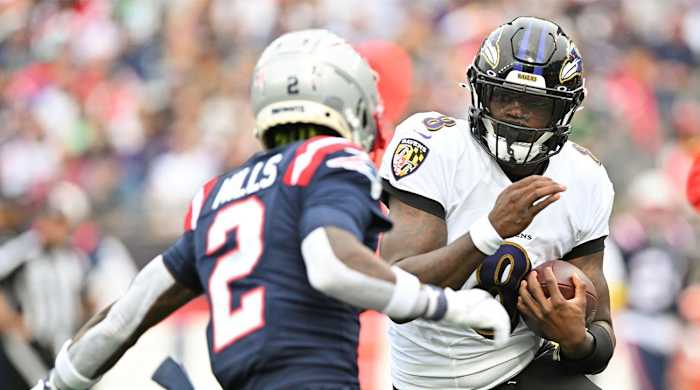 Sep 25, 2022; Foxborough, Massachusetts, USA; Baltimore Ravens quarterback Lamar Jackson (8) runs with the ball against New England Patriots cornerback Jalen Mills (2) during the second half at Gillette Stadium.